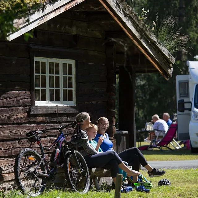 Familie spiser is utenfor hyttevegg